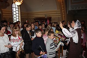 Пані Оля Гусак керує хором під час Святої Літургії
